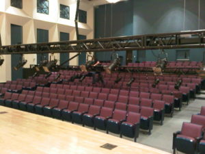 A SkyAscend self-climbing hoist in the down position front of house in a theater.